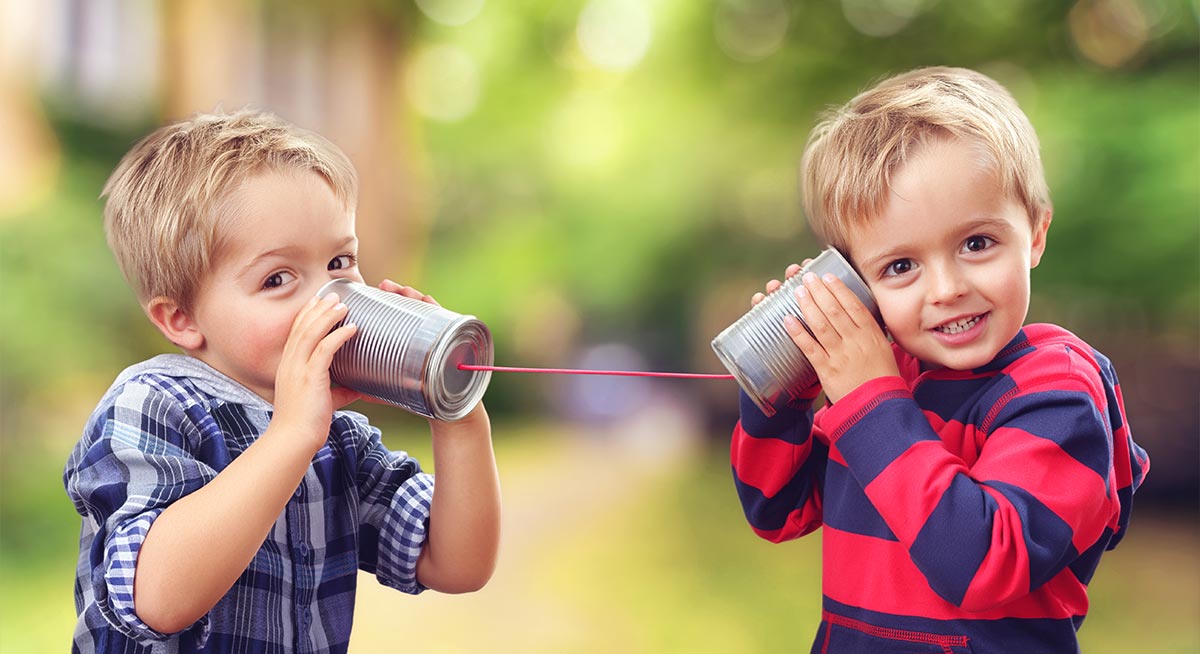 Two boys with cans used as telephones